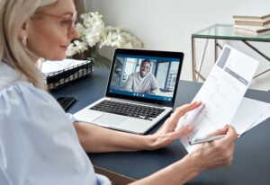 Female recruiter reading cv during online virtual job interview by video call.