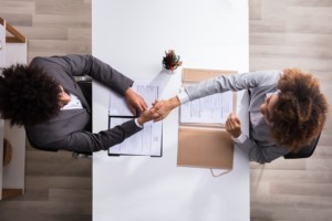 Manager Shaking Hands With Female Applicant At Workplace