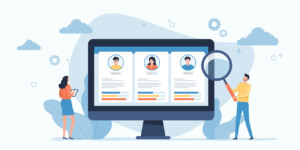 Illustration of two people reviewing candidate profiles on a large computer screen; one person holds a tablet and the other examines the profiles with a magnifying glass.